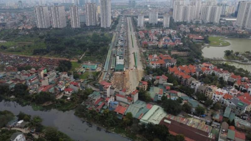 Xe tải nhỏ đang di chuyển qua con đường nội bộ tại khu đô thị Định Công trong giờ vắng.